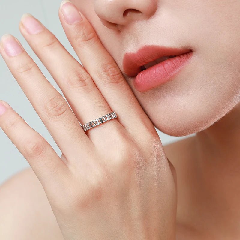 Close-up of a hand wearing a diamond ring with a blurred background