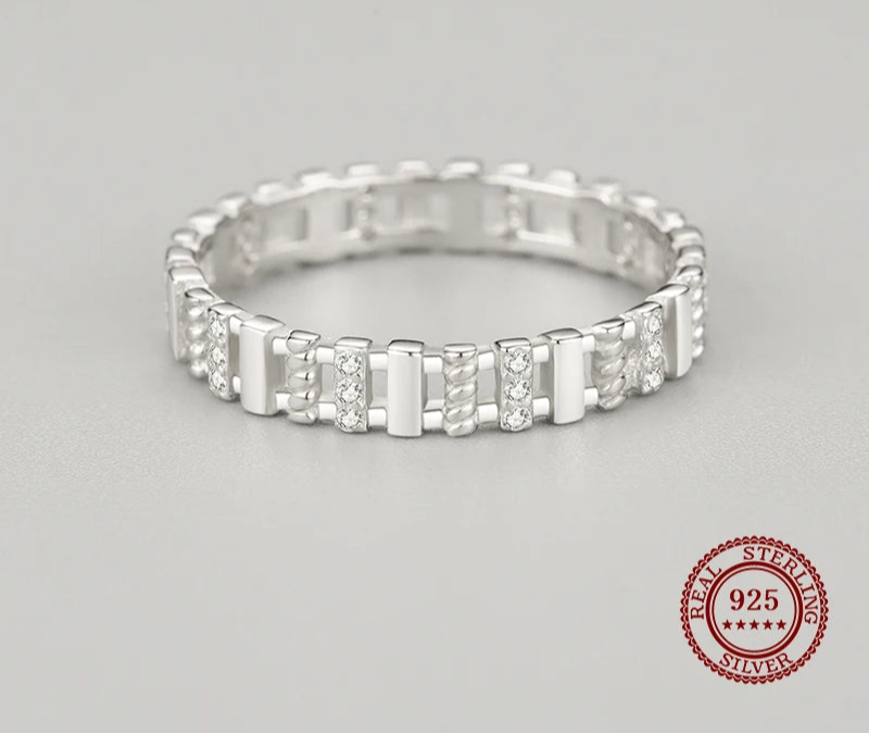 Silver ring with small diamonds on a gray background