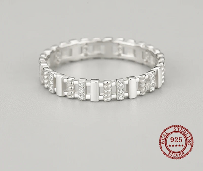 Silver ring with small diamonds on a gray background
