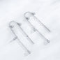 Pair of silver earrings with dangling elements on a white background